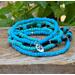 Very pretty 5 stack bracelets of blue and green glass beads with a bear paw charm. This bracelet is stretchable.